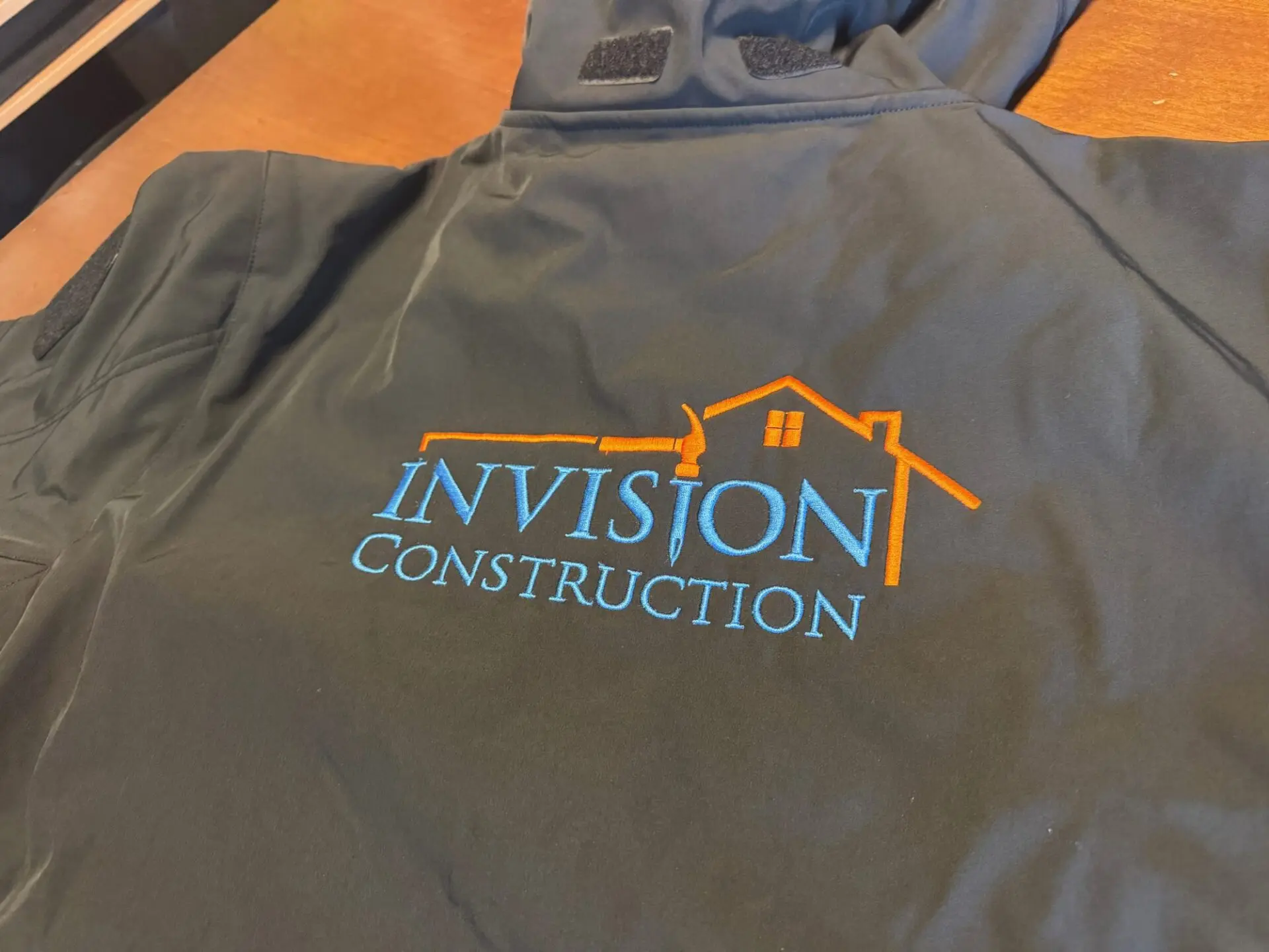 Large custom embroidered logo on the back of a shirt for a construction company in Nampa