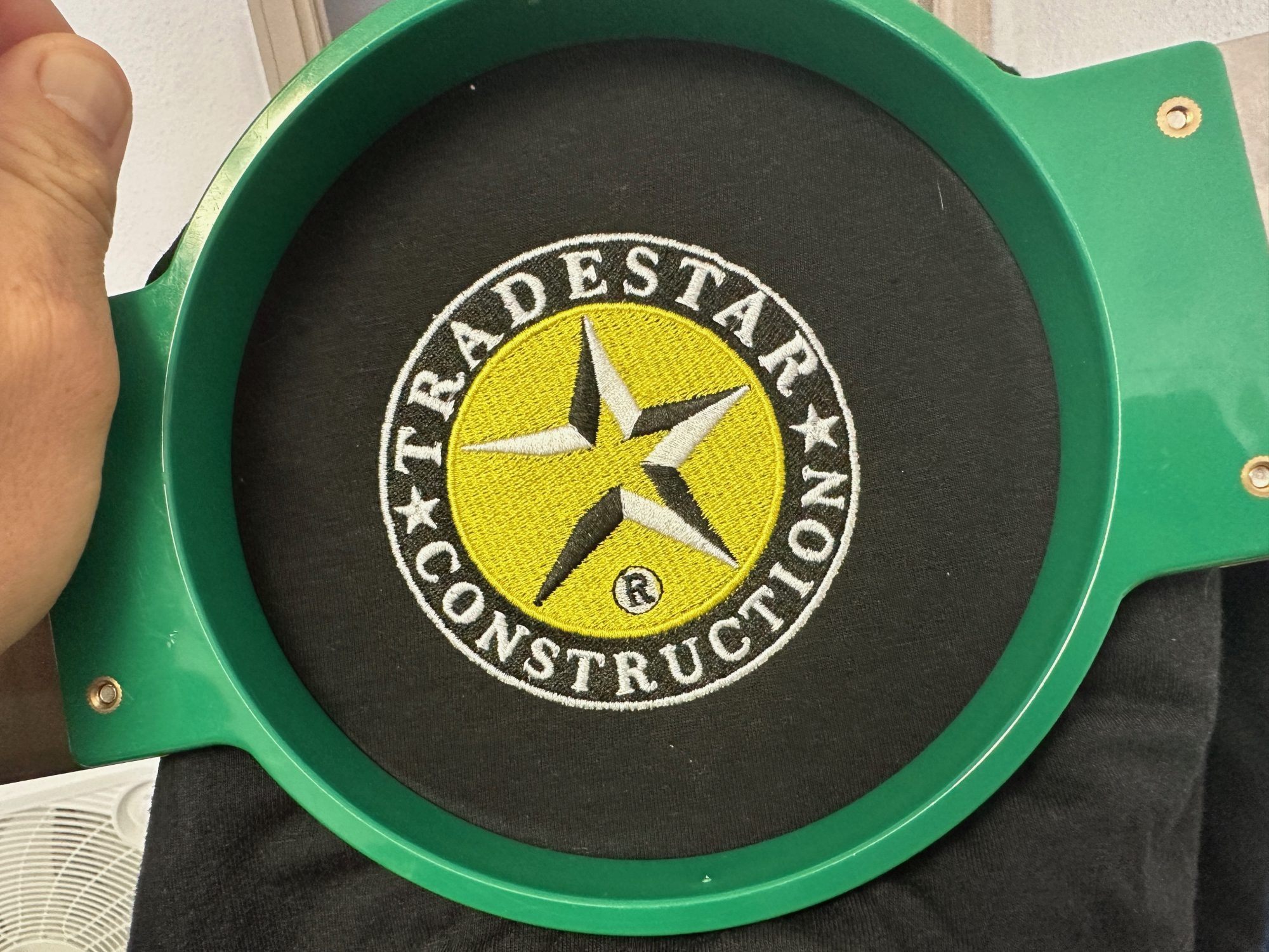 Custom embroidered logo still on the hoop at The Print Plug in Nampa