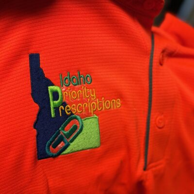 Custom embroidered polo work shirt with logo on right chest for a prescription company near Nampa