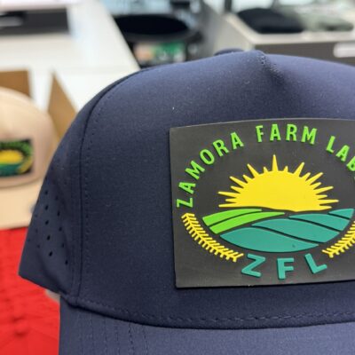 Close up of a custom PVC patch on a dark snap-back hat